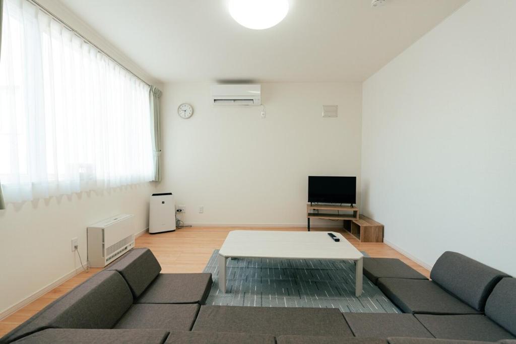 a living room with a couch and a table at ビアンカ Bianca A号室 in Asahikawa