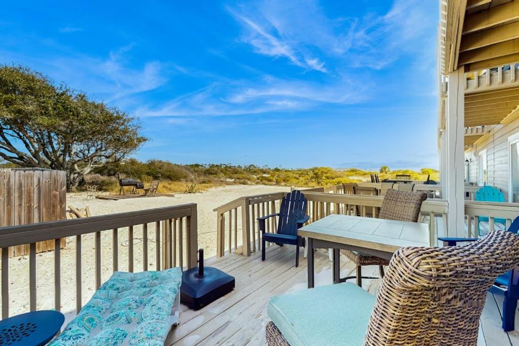 a wooden deck with a table and chairs on the beach at Spacious Condo with full kitchen shared pool and beach access in Perdido Key