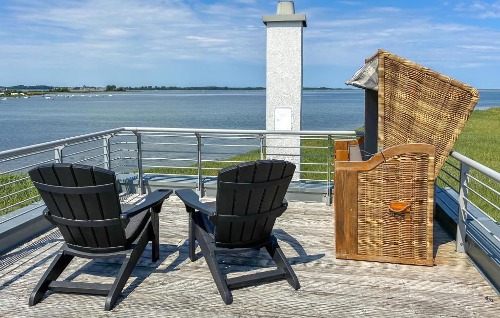 two chairs and a grill on the deck of a boat at Achtern Schilf in Olpenitz