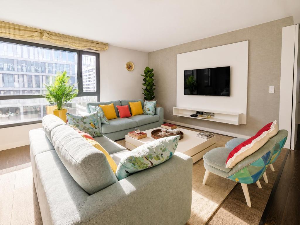 a living room with a couch and a tv at Bom dia Parque Nações LisboaX in Lisbon