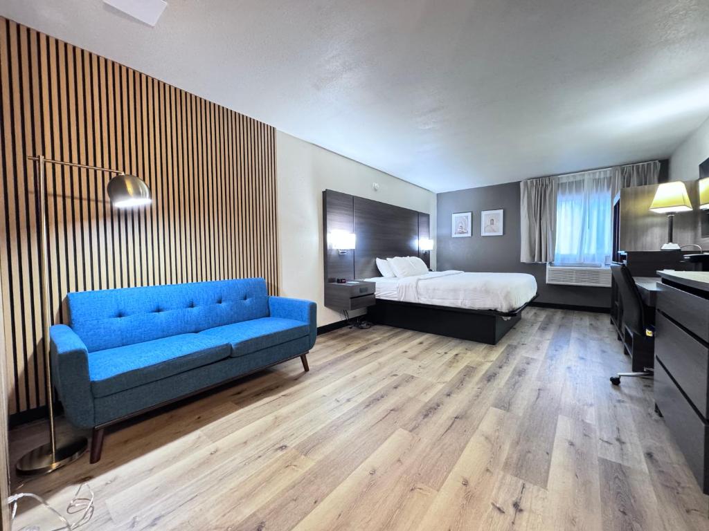 a hotel room with a blue couch and a bed at Quality Inn Spearfish I-90 in Spearfish