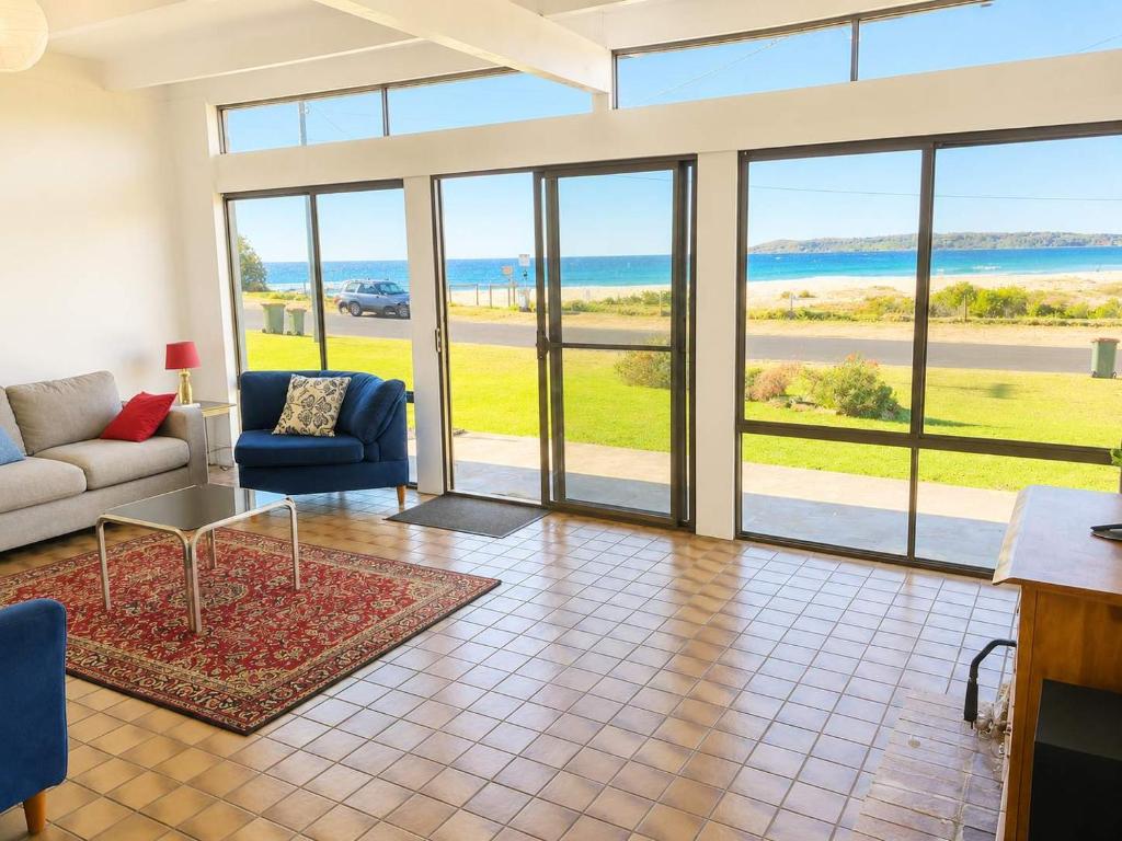 a living room with a couch and a table at Ocean Front on Malibu in Bawley Point