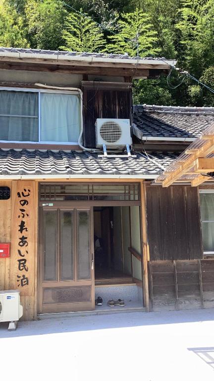 a house with a door and a chair on top of it at 心のふれあい民泊 in Shimanto