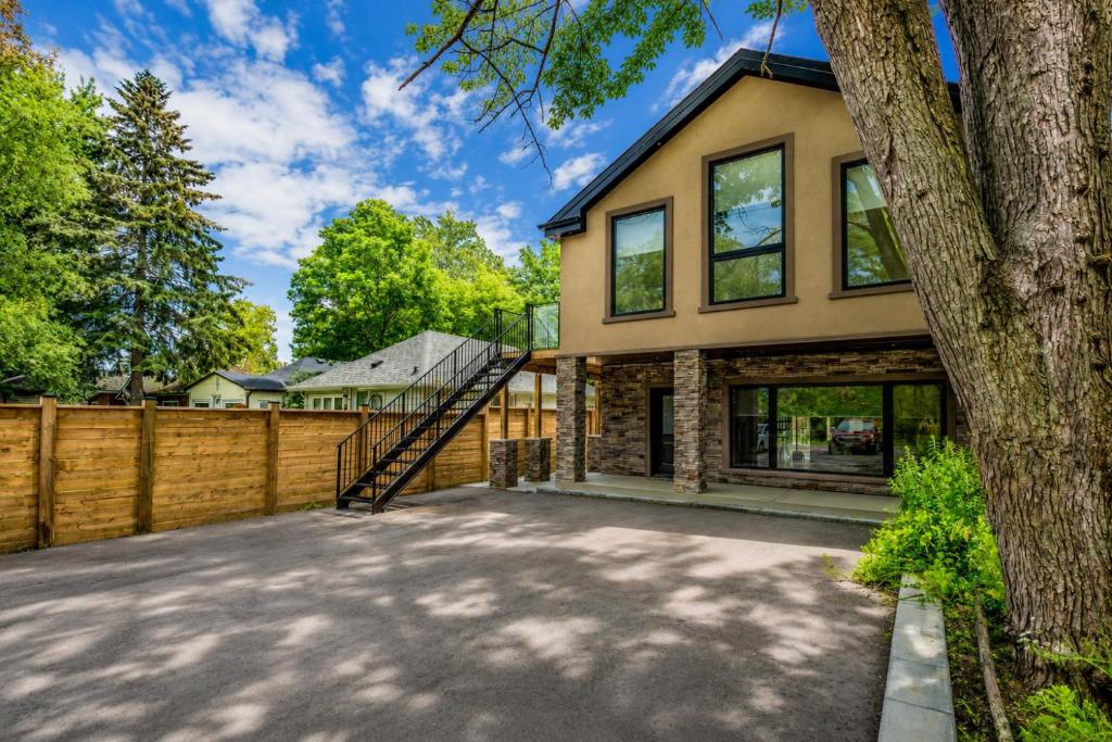 a house with a fence and a tree at Lake House By Lis in Innisfil