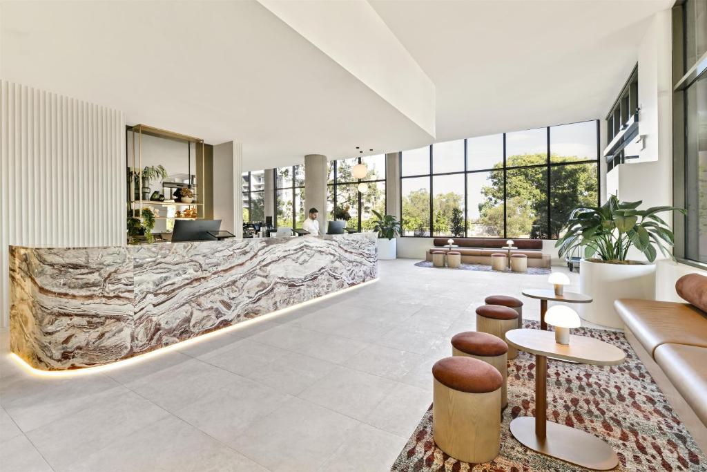 a lobby with a large stone wall at Adina Chermside Brisbane in Brisbane