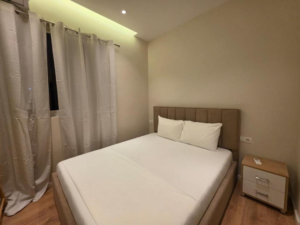 a small bedroom with a white bed and a window at Himara City 10 - Central, Beach Access in Himare