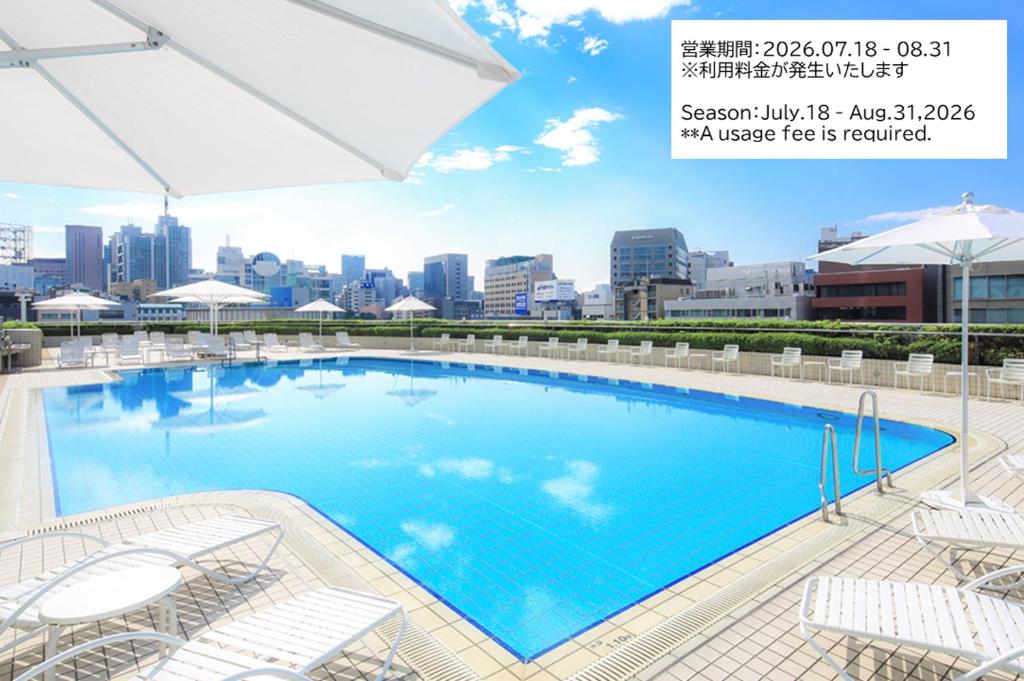 a large swimming pool with a city skyline in the background at Tokyo Dome Hotel in Tokyo