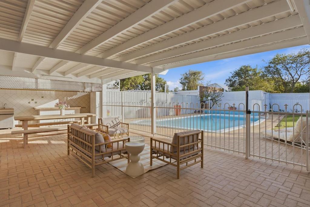 a patio with benches and a swimming pool at Mediterranean Beachside retreat with a pool in Broadwater
