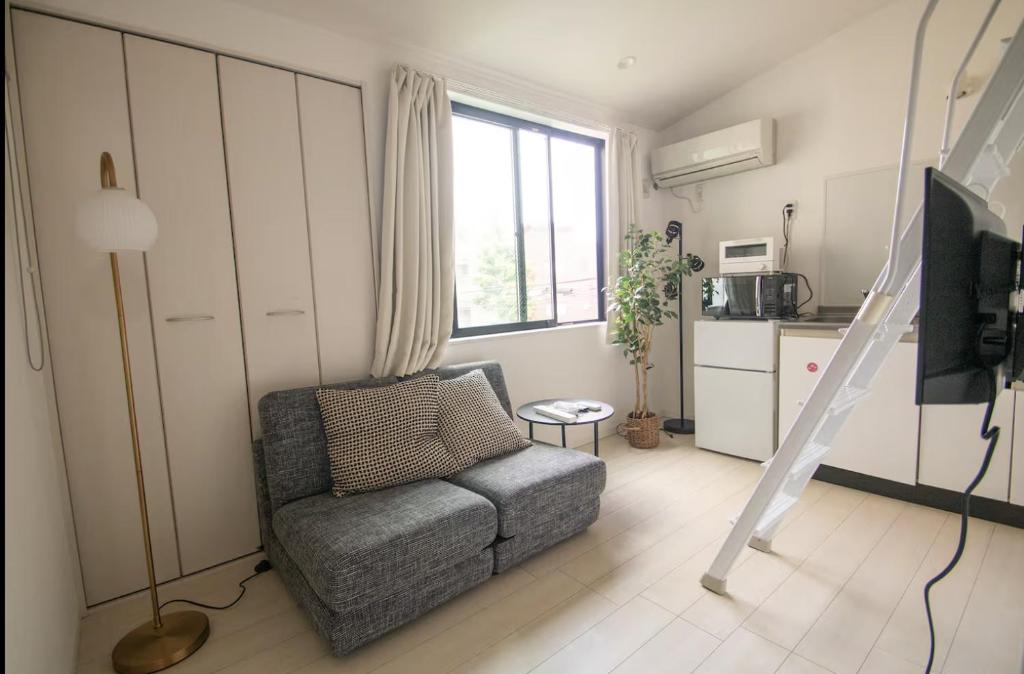a living room with a chair and a kitchen at SCREEN Shibamata 20 mins to Skytree in Tokyo