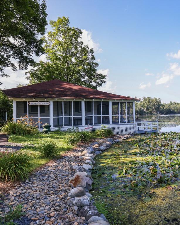 a house with a pond in front of it at Heart's Desire, Cottage with stunning lake views in Effort