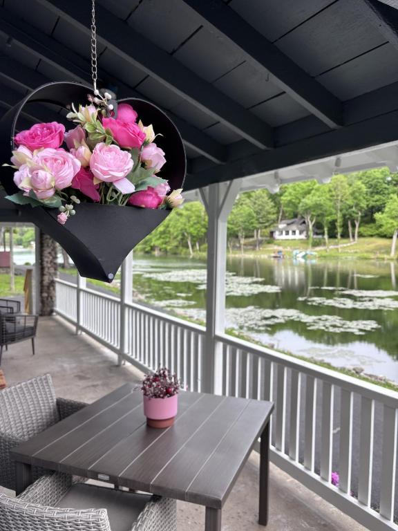 a basket of flowers hanging on a porch with a table at Lakefront Couples Retreat in the Poconos in Saylorsburg