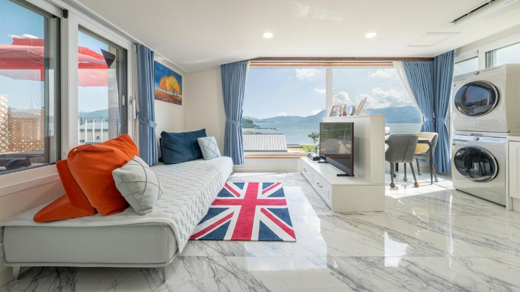 a living room with a couch and a tv at That Day's Namhae Ocean View Pension in Namhae