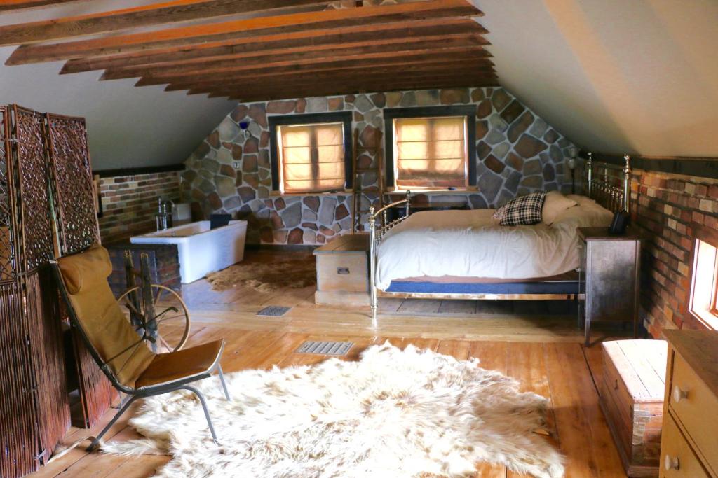 a bedroom with a bed and a stone wall at Maison du Mont-Mégantic in Lac-Mégantic