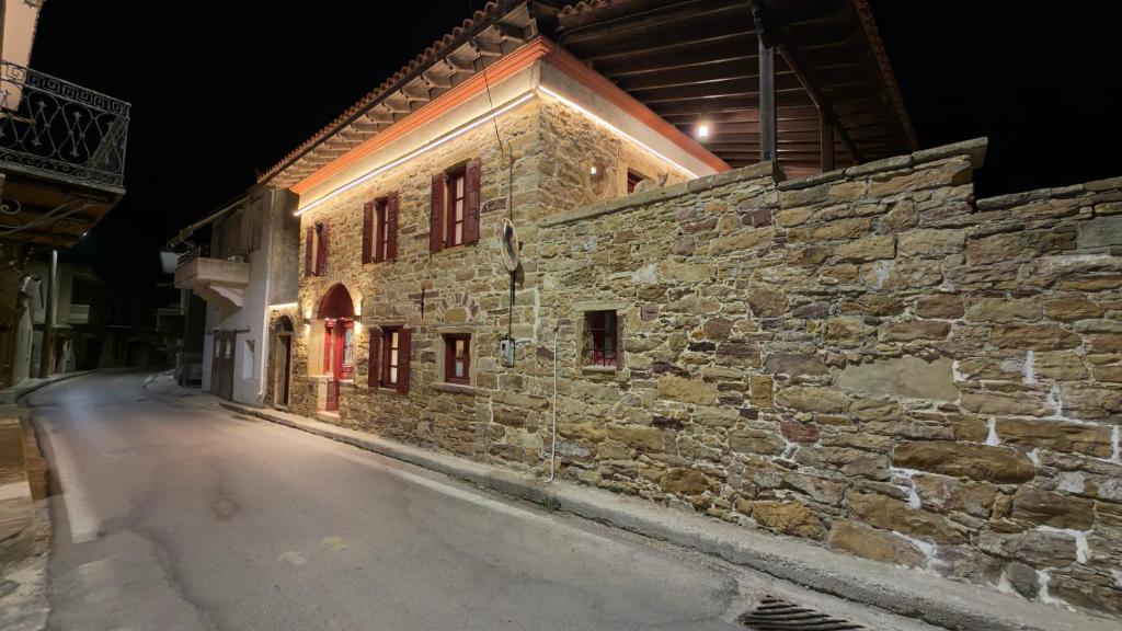 a stone building on a street at night at Archontiko Chios Traditional Mansion in Thymianá