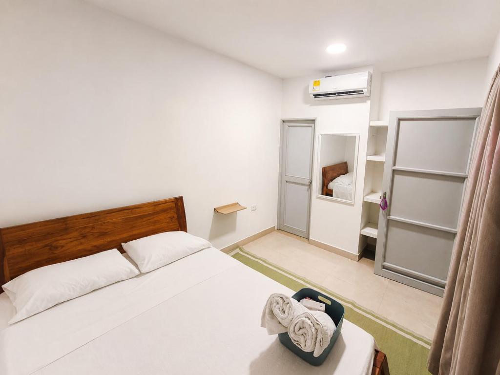 a bedroom with a bed with towels on it at La Casita Rooms - Habitaciones Coveñas in Coveñas