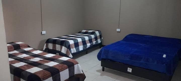 a room with two beds in a room at Posada doña ilene in Quimilí