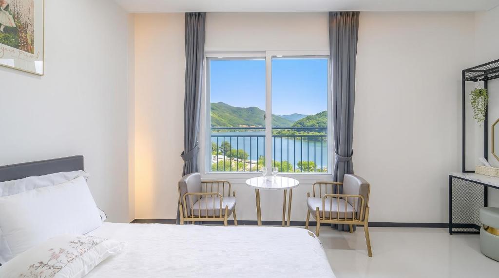 a bedroom with a bed and a table and chairs at Gapyeong Ciere Poolvilla in Gapyeong
