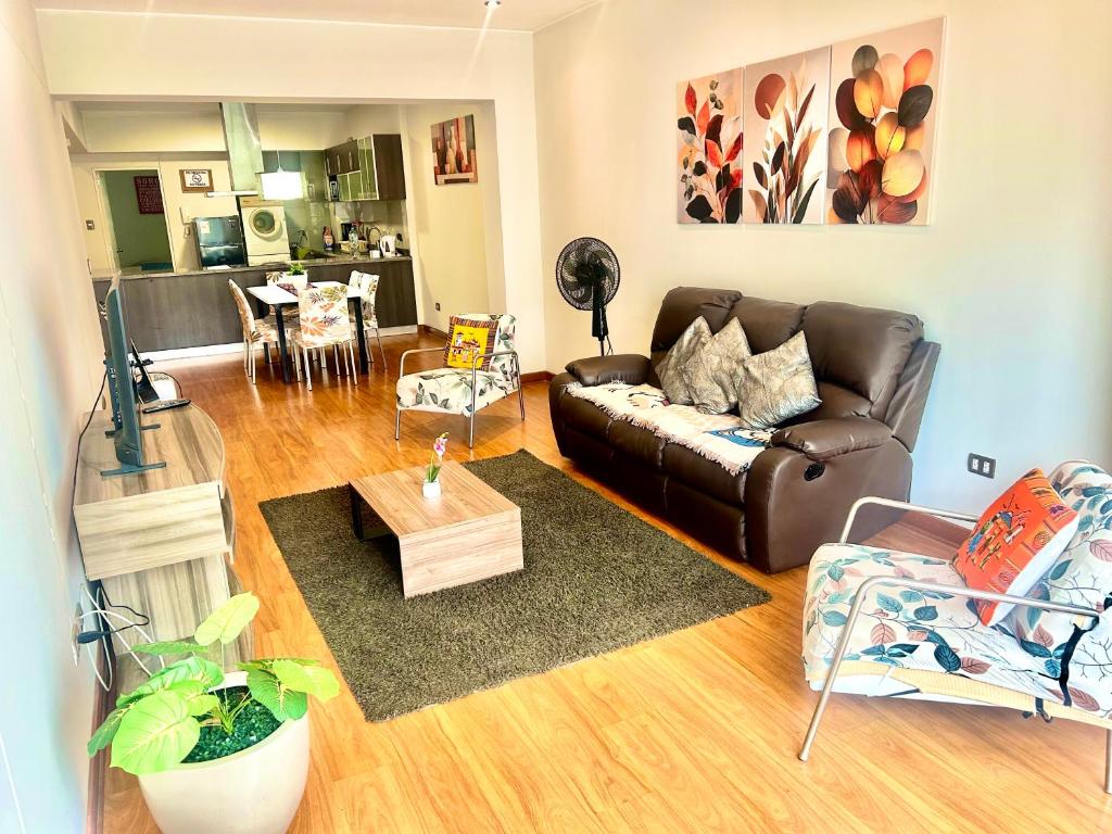 a living room with a leather couch and a table at Spacious Apartment in Miraflores in Lima
