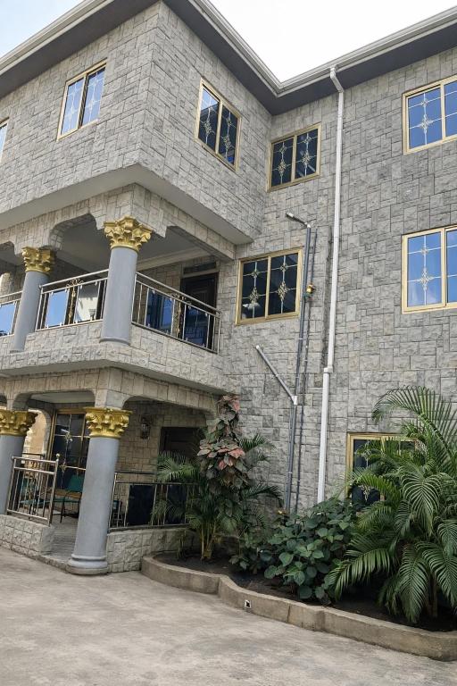 a large stone building with a bunch of windows at Fofana Luxury Suites in Sotuom