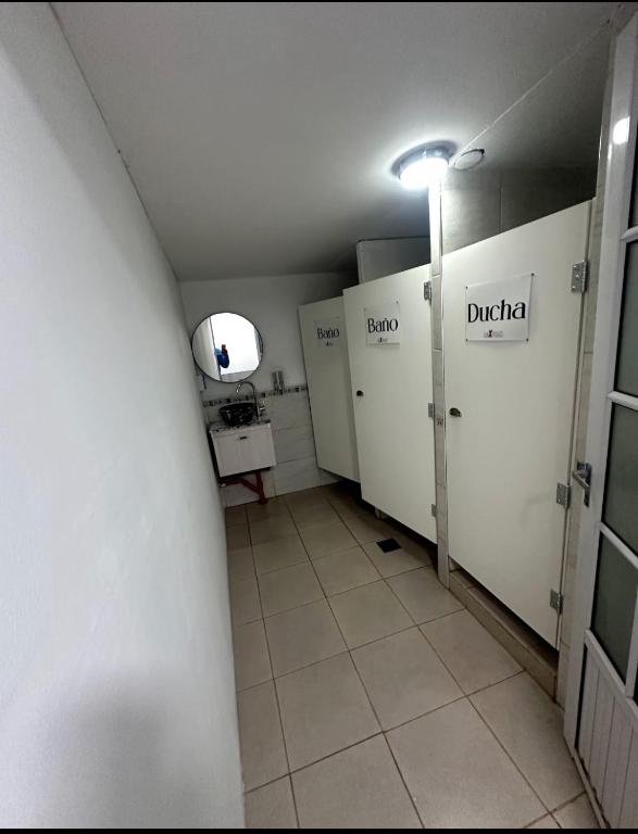 a hallway with white lockers in a bathroom at Hostel Luxfran in Uspallata