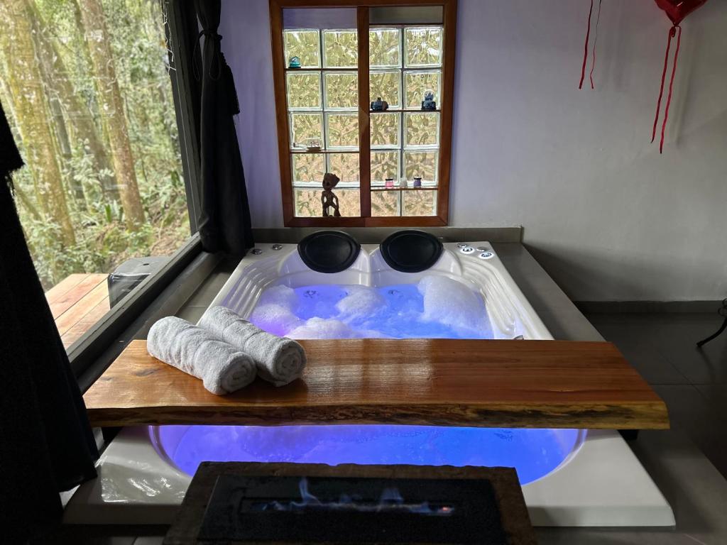 a jacuzzi tub in a room with a window at Chalé Carvalho in Araucária
