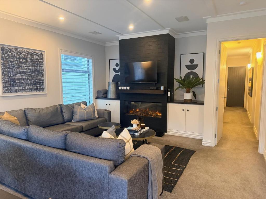 a living room with a couch and a fireplace at Cardrona Mountain Villa in Cardrona