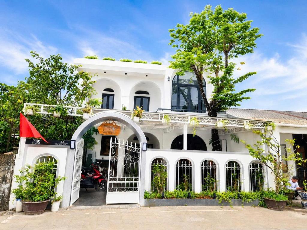a white house with a tree in front of it at BY Home in Hue