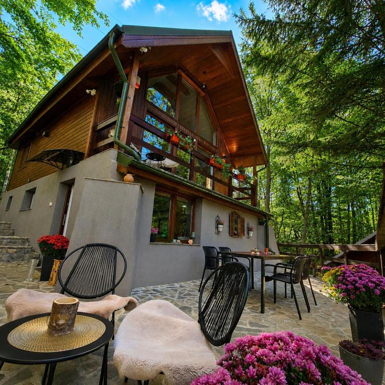 a small house with chairs and tables and flowers at Wild House in Sinaia