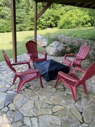 three chairs and a table on a stone patio at Beacon Hill Lake House in Pinnacle