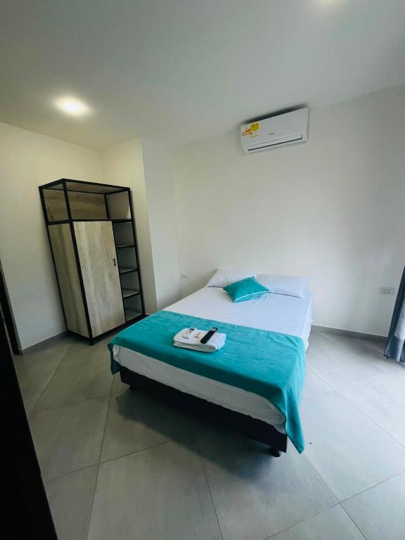 a bedroom with a bed with a blue comforter at BLUE DAYS Hotel Melgar in Melgar