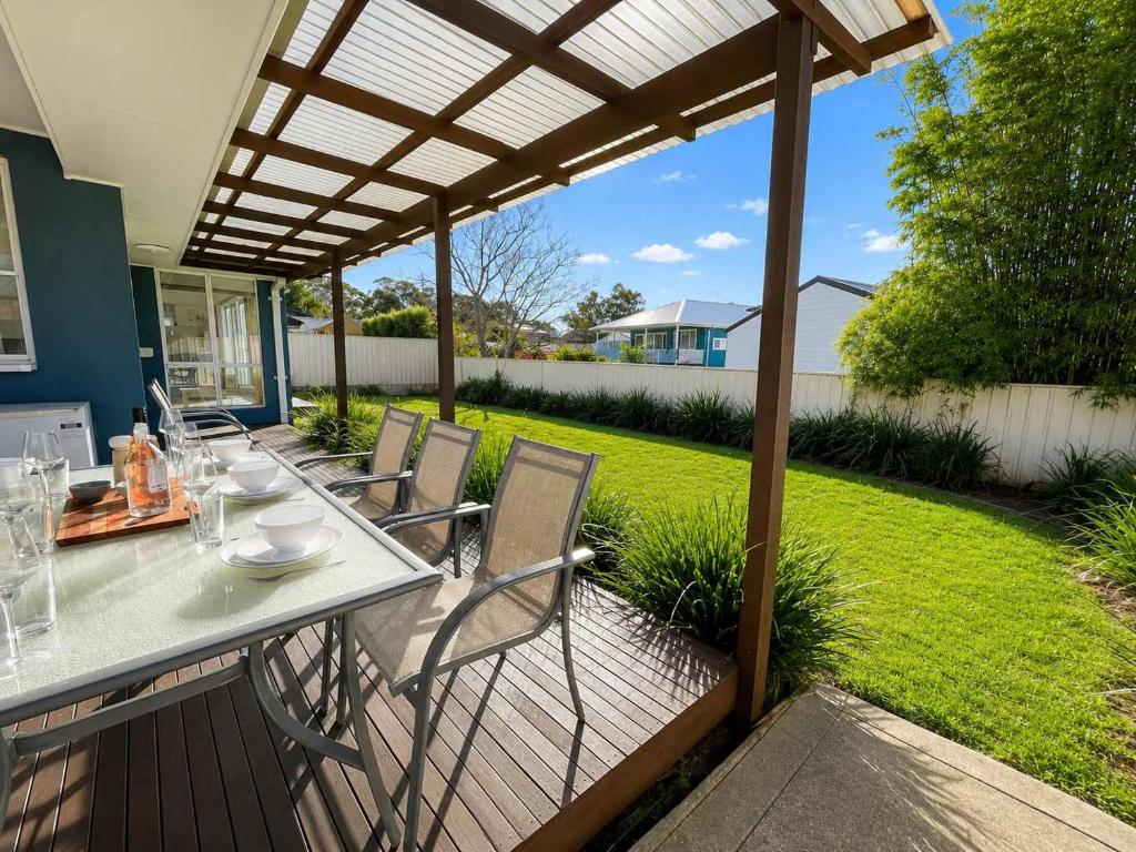 a patio with a table and chairs under a pergola at The Coastal Haven in Manyana