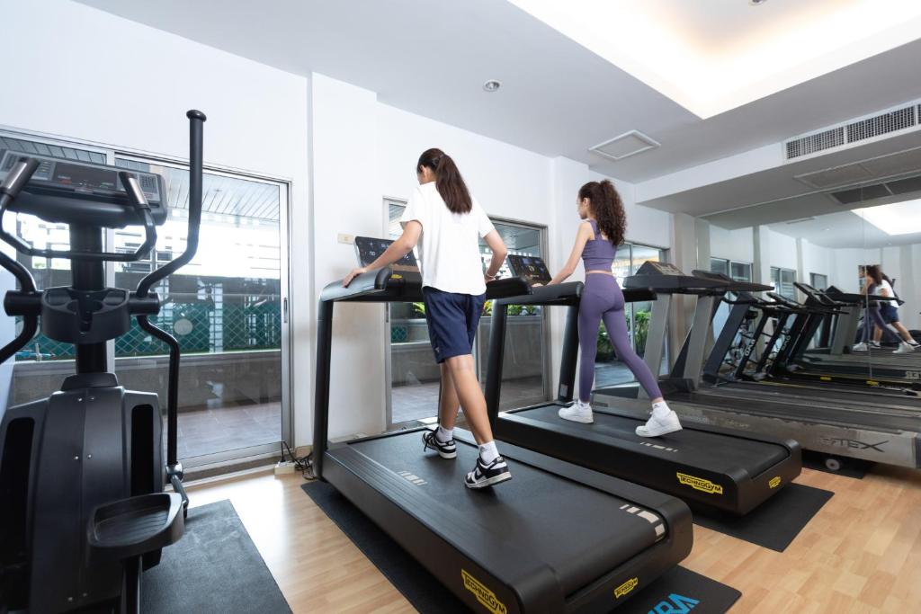 A bright gym with guests using treadmills and several cardio machines.