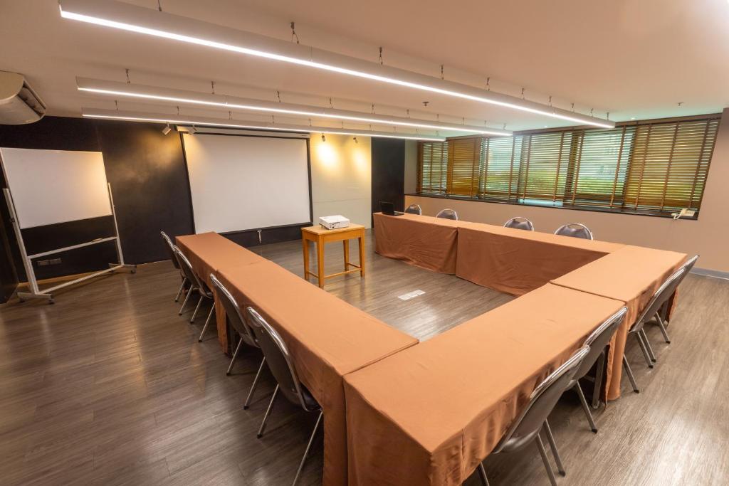 A wood-floored conference room arranged around a U-shaped table.