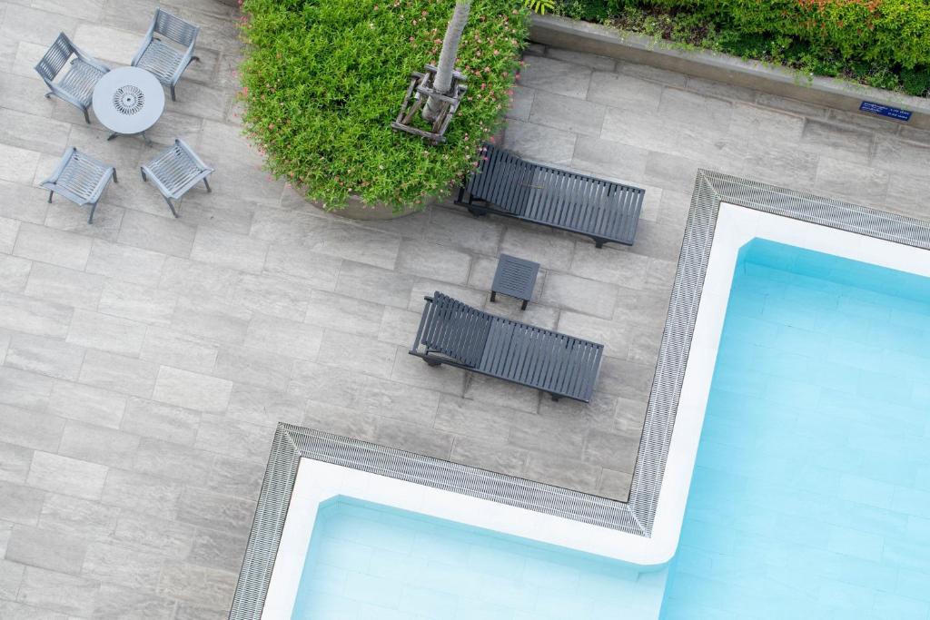 A top-down view of the pool corner, loungers and small outdoor dining area.