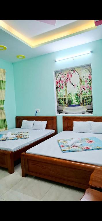 two beds in a room with blue walls at 846 A12 Bùi Thiện Ngộ in Cù Lao Tâu