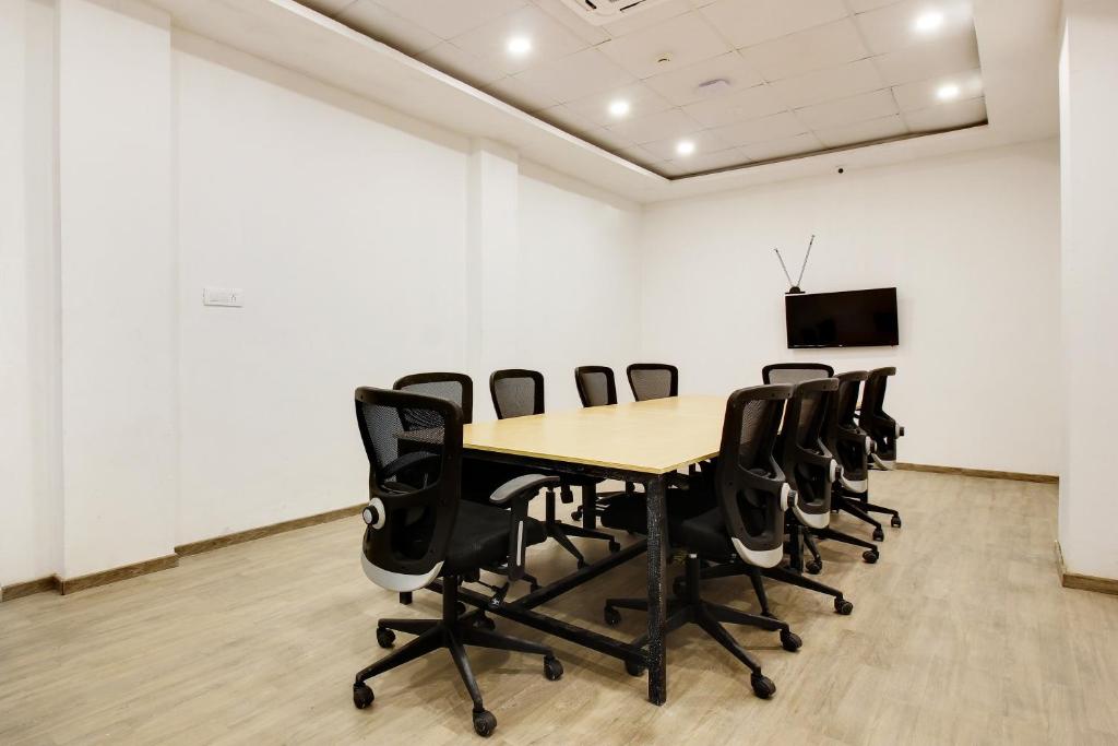 a conference room with a wooden table and chairs at Super townhouse moosapet Rcc Prime in Hyderabad