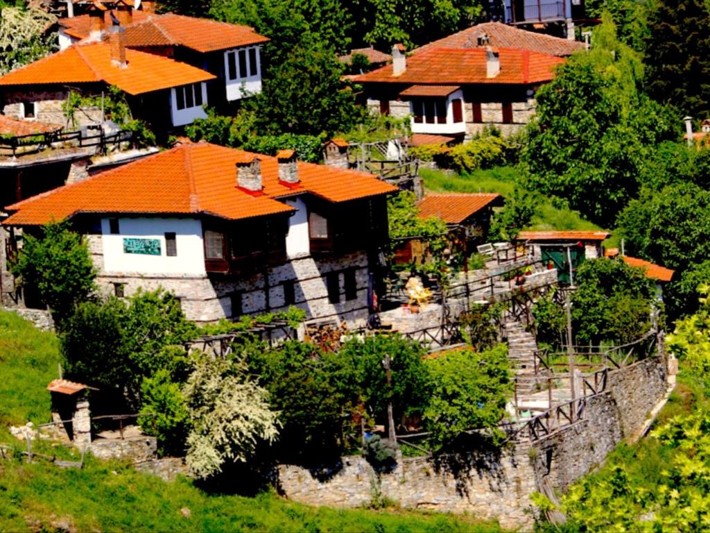 a group of houses with orange roofs on a hill at Feggaropetra Inn Magic Mountain House in Palaios Panteleimon