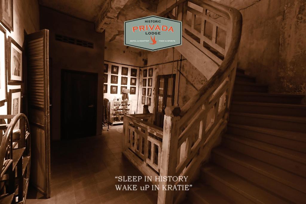 a stairway in a house with a sign that reads sleep in history wake up at Privada Lodge - Historic Hotel in Kratie