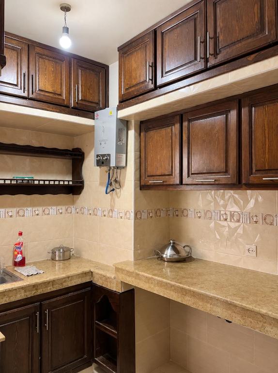 a kitchen with wooden cabinets and a counter top at Perfect home in Temara
