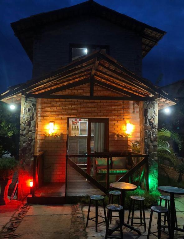 a small building with stools in front of it at night at Estação Serrana in Pedro II