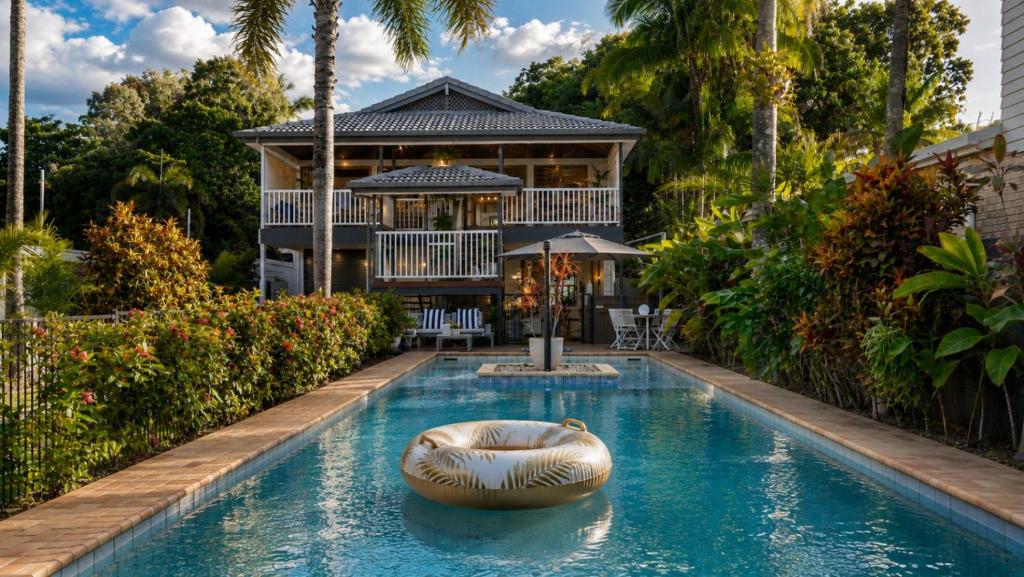 a house with a swimming pool with a boat in it at The Arlington Beachfront House in Clifton Beach