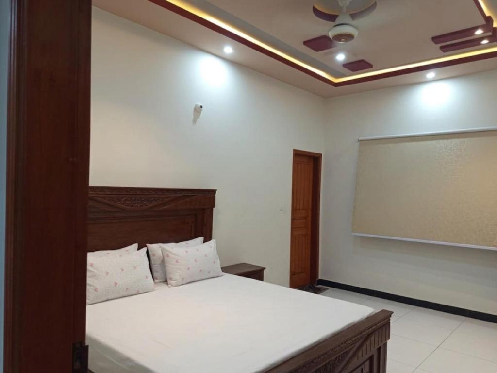 a bedroom with a bed and a projection screen at Nursery Lodge Guest House in Karachi