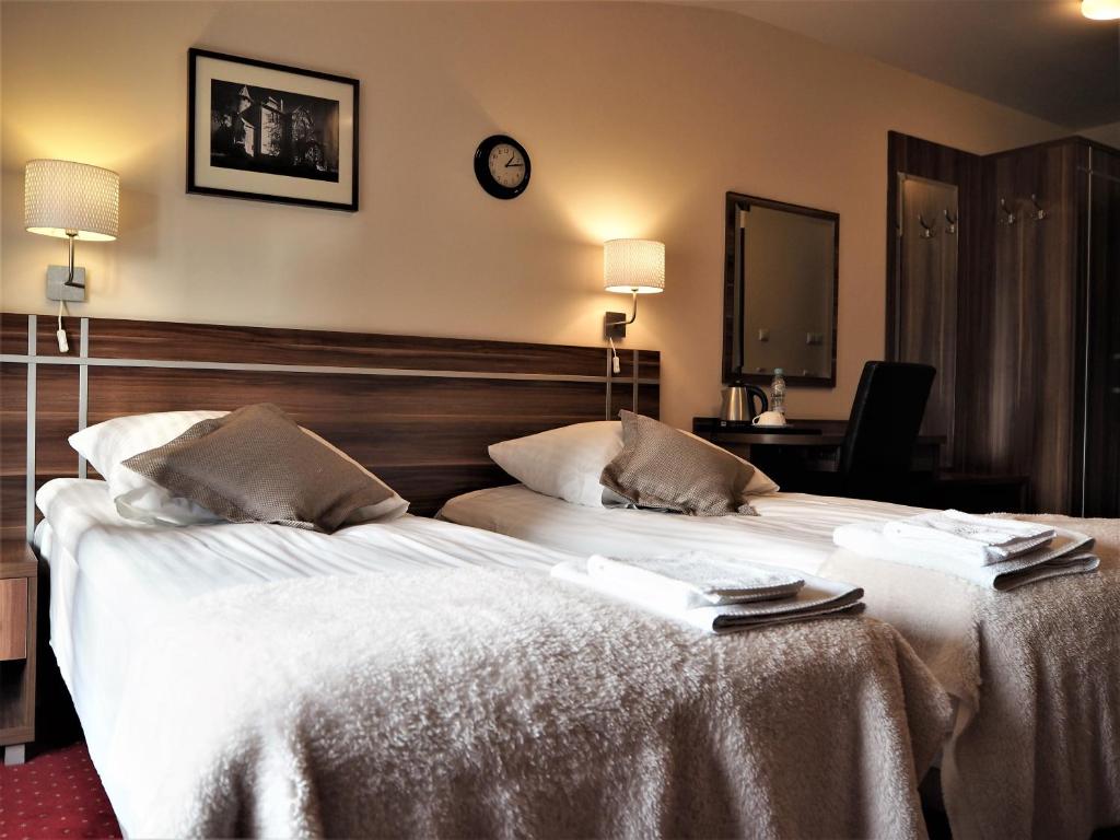 - une chambre d'hôtel avec 2 lits et des serviettes dans l'établissement Villa Masoneria, à Łódź