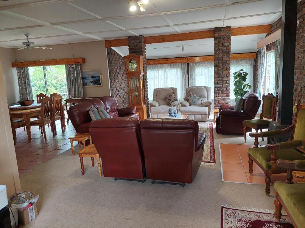 a living room with leather furniture and a dining room at Eagle Waters in Vanderkloof