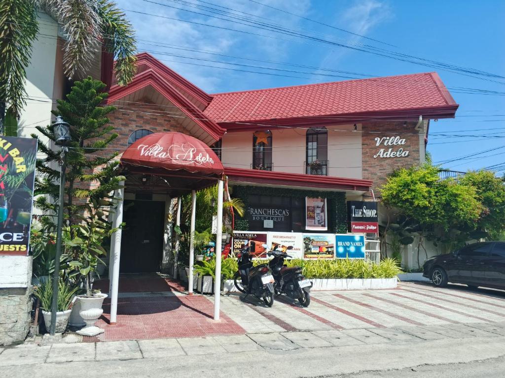 a store with two motorcycles parked in front of it at Villa Adela Pension House in Balamban