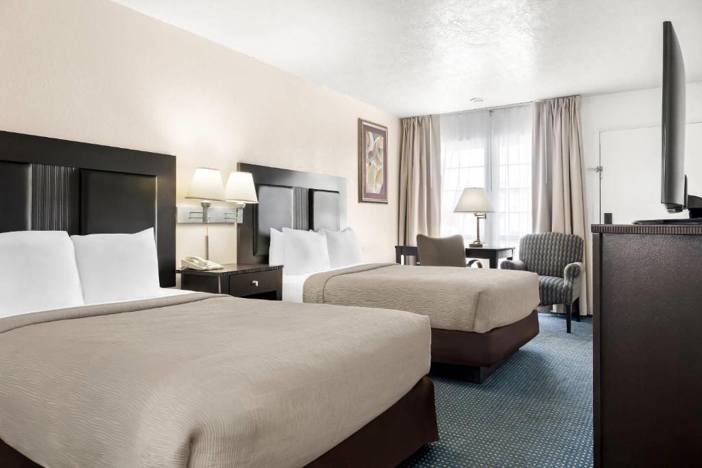a hotel room with two beds and a desk at Quality Inn Rock Springs - Green River in Rock Springs