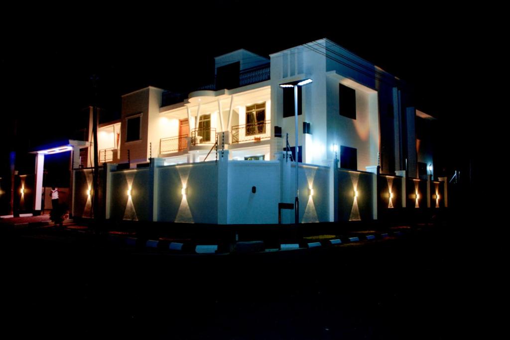 a large white house with lights on it at night at Obama Apartments in Mbweni