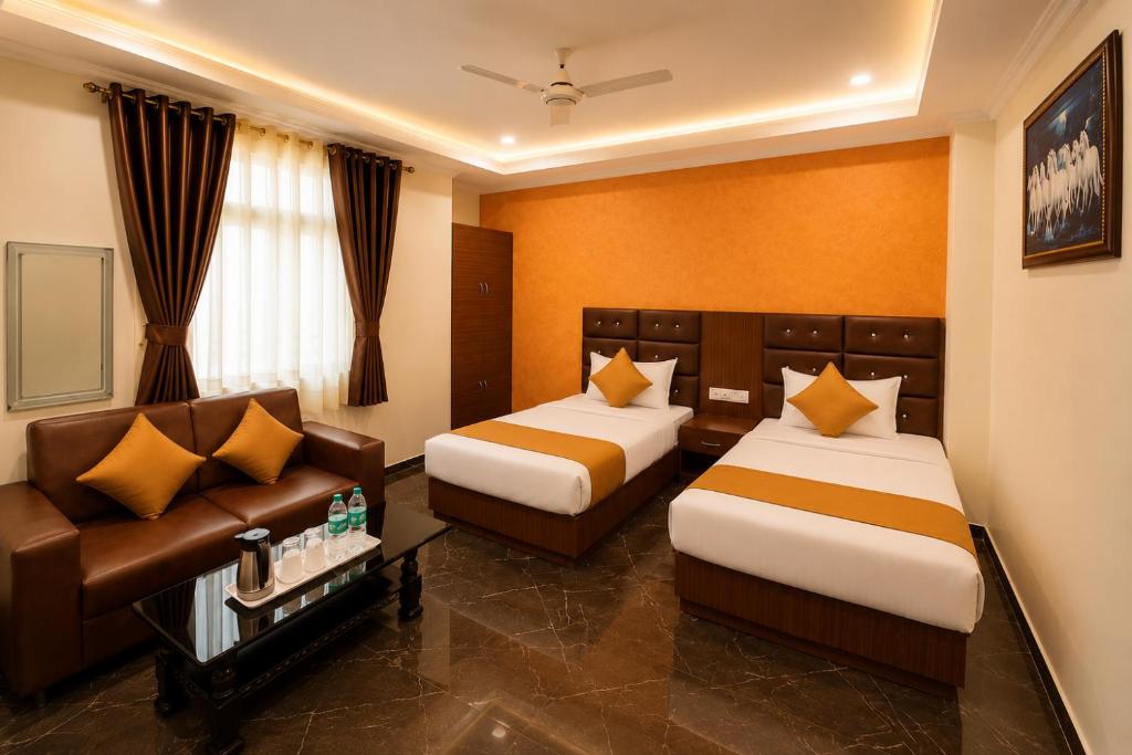 a hotel room with two beds and a couch at Hotel Hyfa Continental in Lucknow