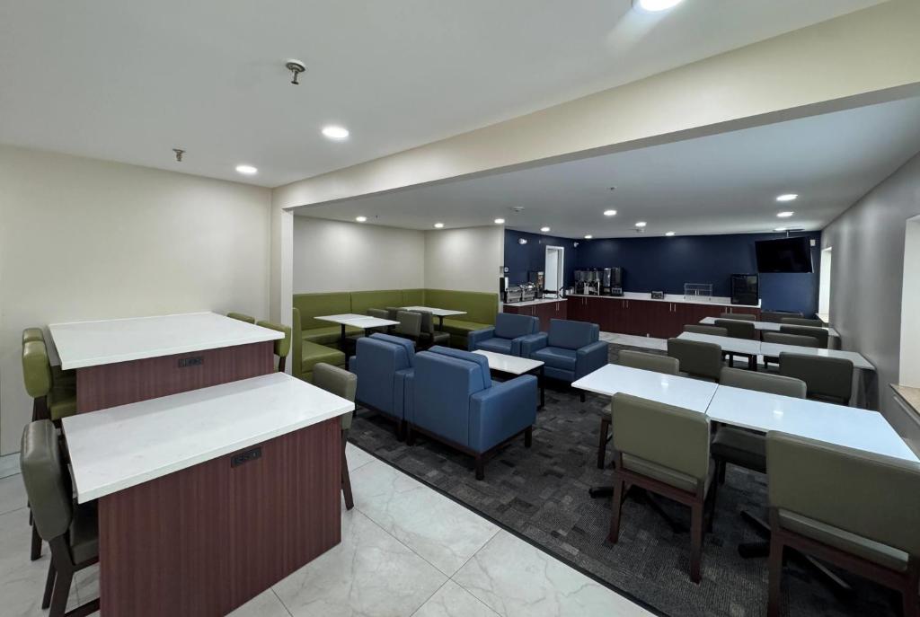 a restaurant with tables and chairs and a bar at La Quinta Inn by Wyndham Auburn Worcester in Auburn