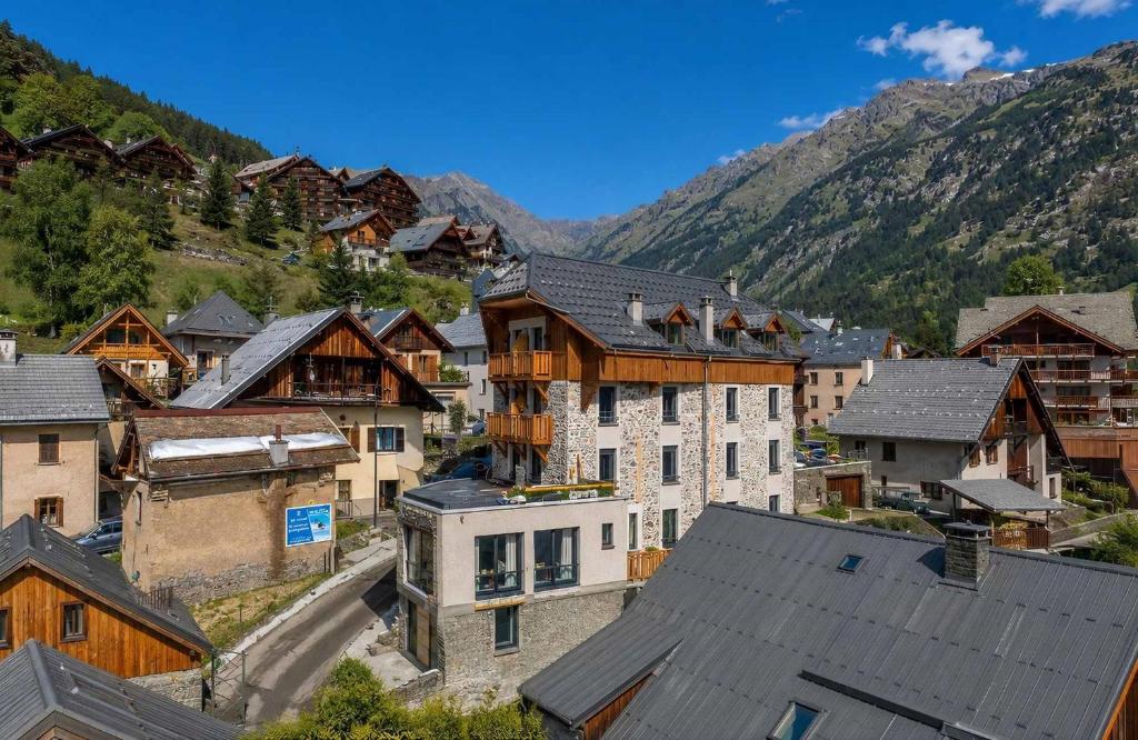an aerial view of a village with houses and mountains at Madame Vacances Hotel Les Cimes in Vaujany